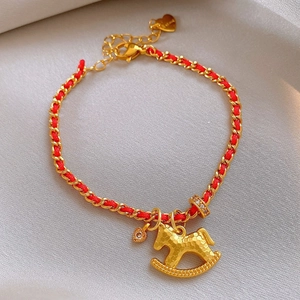 Red woven bracelet with golden rocking horse pendant and sparkling zircon accents