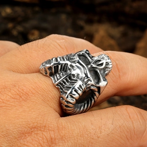 Close-up of vintage stainless steel ram skull ring worn on finger with punk style details