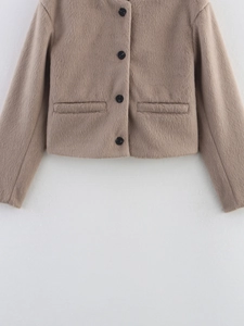 Detail of wool blend cropped jacket with black buttons and soft camel plush texture