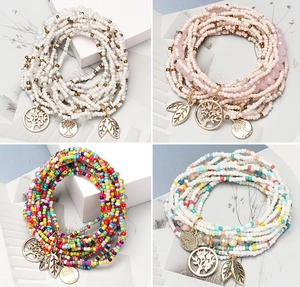 Detail of bohemian handmade multilayer seed bead bracelets with Tree of Life pendants