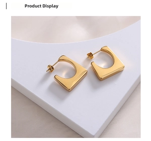Detailed view of gold geometric trapezoid earrings with polished hollow square design