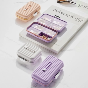 7-day portable pill organizer with suitcase texture and sliding numbered compartments