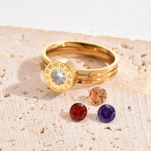 Anello d'oro con numeri romani e zirconi su pietra di travertino beige