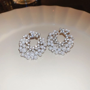 Gros plan de boucles d'oreilles argentées en C avec perles blanches et strass brillants
