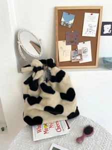 Detail of plush tote bag showing knotted handle and blue checkered inner lining