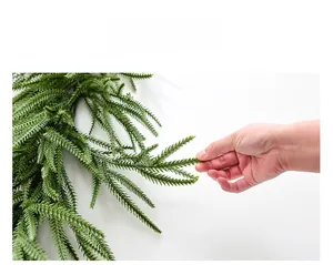 Close-up of lifelike Norfolk pine garland needles in a natural green finish