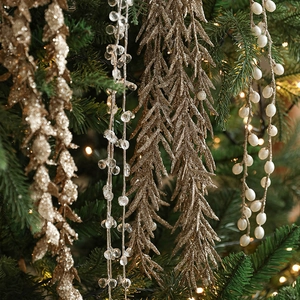 Glittering gold Christmas tree ornaments with beads and faux berries in festive setting
