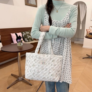 Detail of white quilted tote bag featuring a cute rabbit floral print and zakka label