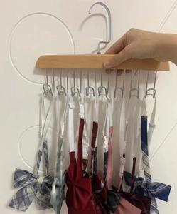 Multi-hook solid wood hanger showcasing various plaid and solid bow tie neckties
