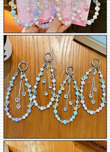 Four colorful beaded phone straps with heart charms and iridescent crystals on wood.
