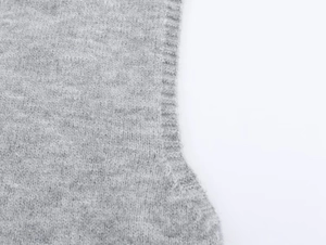 Detail of gray knit vest showing premium ribbed edges and fine texture craft