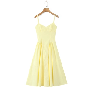 Détail d'une robe midi jaune à bretelles, col en V, taille cintrée et ourlet plissé