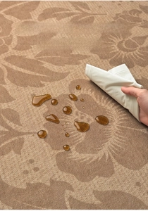 Close-up of waterproof vintage floral rug showing liquid beading on woven surface