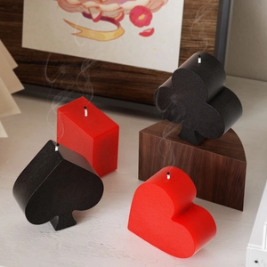 Minimalist poker suit candle set featuring heart and spade shapes on a wood background