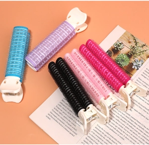 Macro shot of colorful plastic hair volume clips in blue, purple, and pink on a magazine