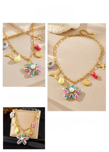 Detailed macro view of gold shell and flower ocean charms on a high-end beach necklace
