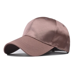 Detalle de gorra de béisbol de satén rosa palo con acabado brillante y visera curva