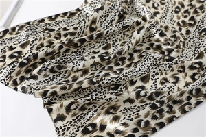 Close-up of leopard print satin scarf showing smooth silk texture and glossy finish