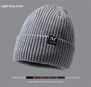 Detailed view of light grey ribbed knit beanie with brand label and color options