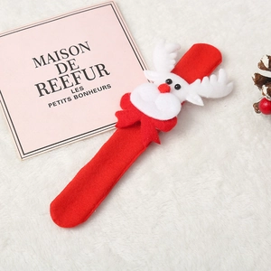 Detail of red plush elk snap bracelet for Christmas kids gifts on white faux fur background