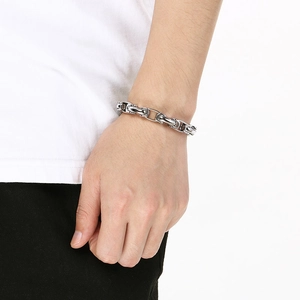 Gros plan d'un bracelet à maillons réglables en argent sur un poignet d'homme