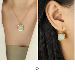 Close-up of light green square stone necklace and matching earrings set in gold