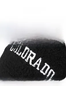 Detail view of white COLORADO embroidery on a black fleece baseball cap fabric