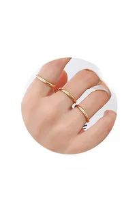 Detail view of 4-piece set minimalist gold stacking rings on hand with ring text