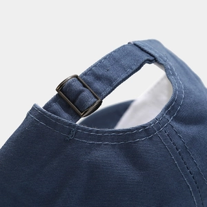 Detail of the navy blue cotton baseball cap with adjustable antique bronze metal buckle