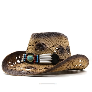 Détail d'un chapeau de cowboy en paille tressée avec bande ethnique et pierre turquoise