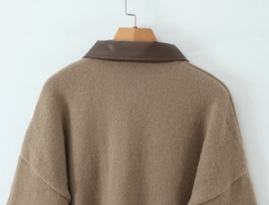 Close-up of brown knit cardigan featuring a faux leather collar and drop shoulder detail