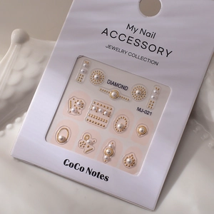 Detailed view of MJ-021 nail art set with pearls and golden metallic studs on white card
