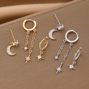 Detailed view of gold and silver star and moon earrings set with sparkling zircon