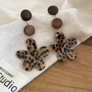 Detail of leopard print flower earrings with resin beads and brown wooden elements