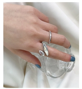 Minimalist S925 sterling silver ring set on a hand holding a glass bottle