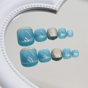 Faux ongles d'orteils bleu lac effet œil de chat et paillettes argentées sur miroir