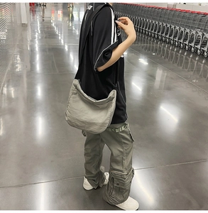 Detailed view of grey large capacity nylon crossbody bag worn by a model in casual setting