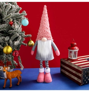 Detail of pink knitted Christmas gnome with retractable legs in a festive home setting