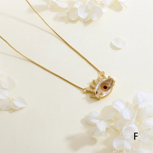 Close-up of gold evil eye necklace with amber zircon stone and white hydrangea petals