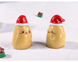 Close-up of a miniature potato doll with a red Santa hat in a snowy micro landscape