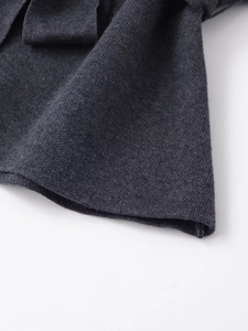 Dettaglio della trama in maglia grigio scuro e delle cuciture dell'orlo di qualità