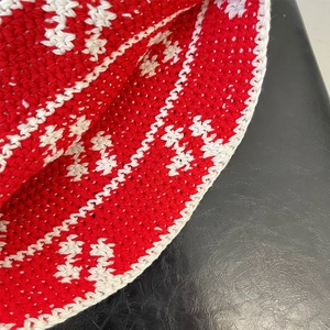 Close-up of the handcrafted red and white crochet knit texture on a bucket hat