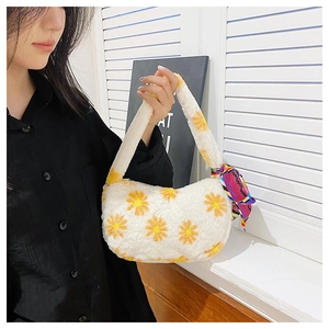 Close-up of white plush shoulder bag featuring daisy embroidery and decorative silk scarf