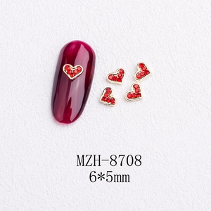 Detailed view of 6x5mm red heart nail art charms with golden alloy base on a white surface