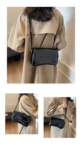 Detail of vintage black glossy oil-wax leather shoulder bag with gold hardware buckle
