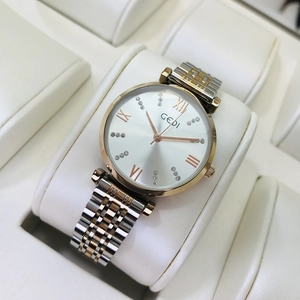 Close-up of GEDI watch with white dial, rose gold accents, and crystal markers on display