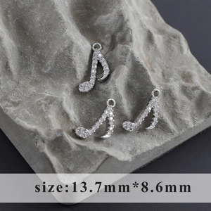 Macro shot of silver-plated eighth note charms with pavé cubic zirconia for DIY jewelry