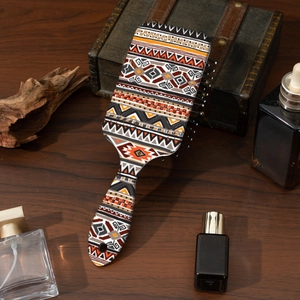 Detail of bohemian style paddle brush with geometric ethnic patterns on wood surface