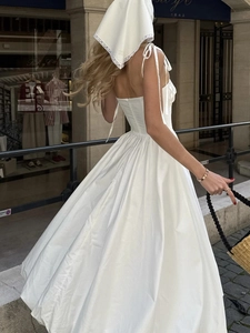 Détail d'une robe blanche en coton dos nu avec bretelles nouées et style français élégant