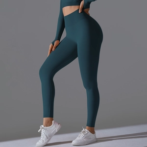 Detail of dark teal yoga set featuring high waist leggings and thumbhole crop top sleeves